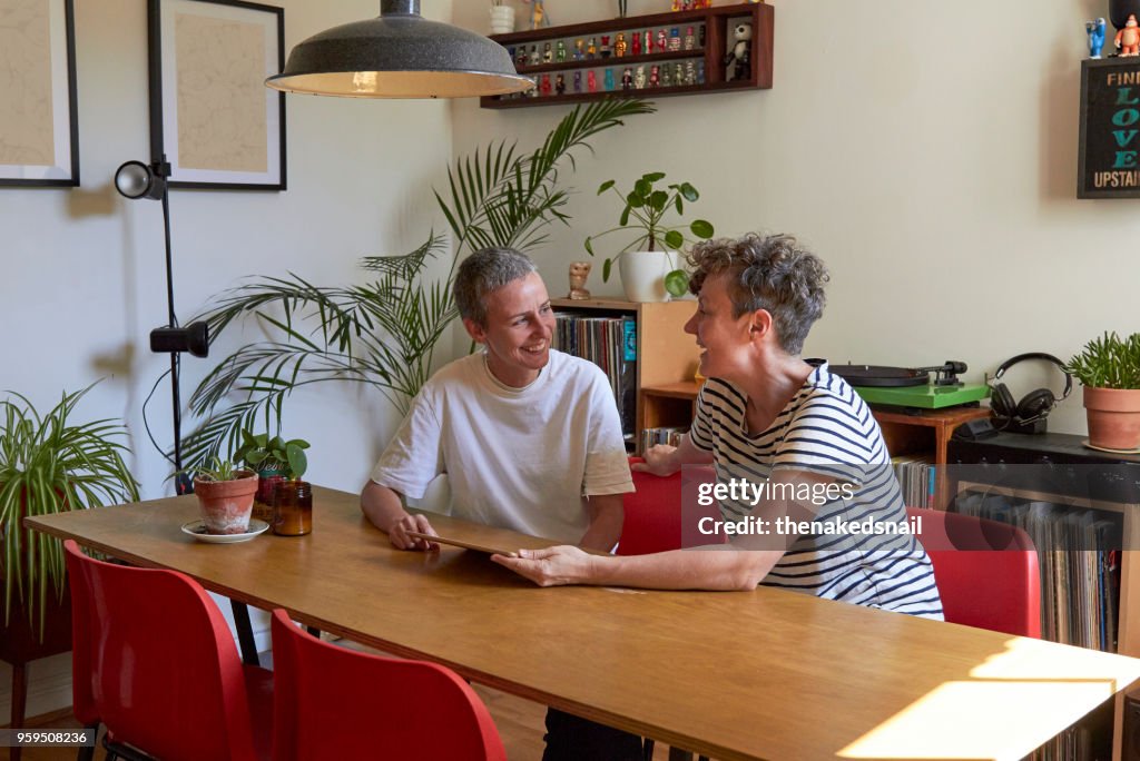 Female couple discussing finances together in their dining room