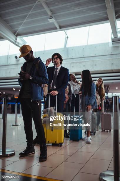 multi-ethnic travelers waiting in line for check-in at airport - lining up imagens e fotografias de stock