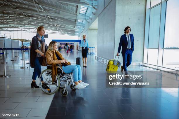 crowd of people with luggage at international airport - medical tourism stock pictures, royalty-free photos & images