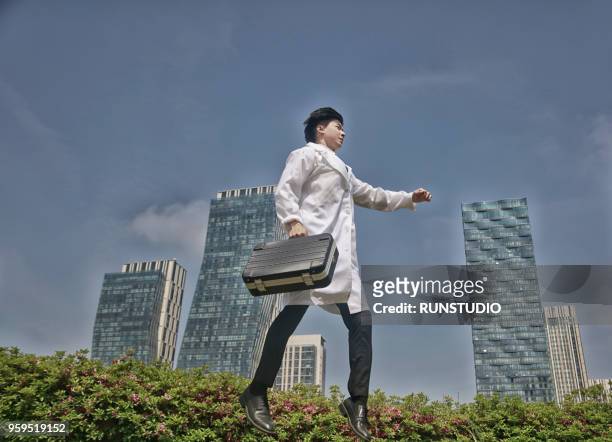 doctor jumping in the air with briefcase - doctor leaping stock pictures, royalty-free photos & images