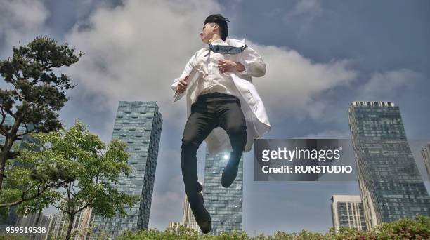 doctor jumping with file - doctor leaping stock pictures, royalty-free photos & images