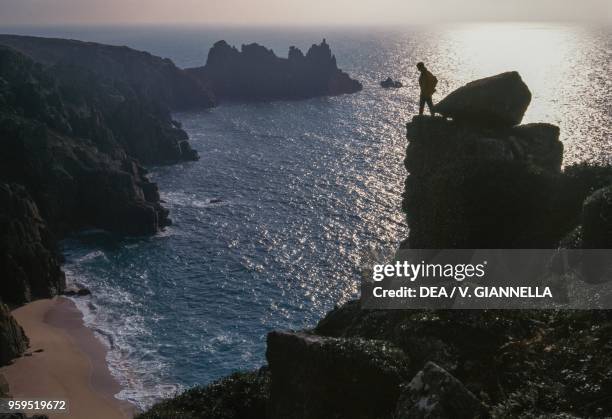 Porthcurno cliffs, with Logan Rock cape in the distance, Cornwall, United Kingdom.