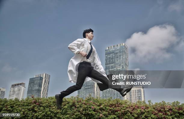 doctor jumping with briefcase - doctor leaping stock pictures, royalty-free photos & images