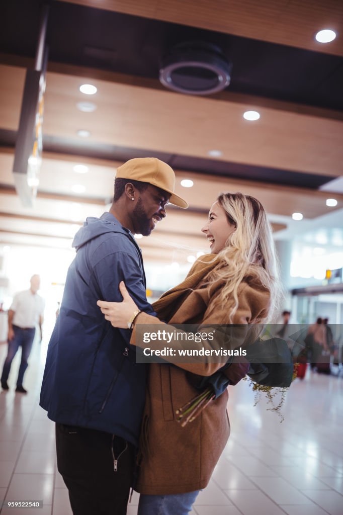 興奮的多族裔朋友在機場的航班抵達後會議