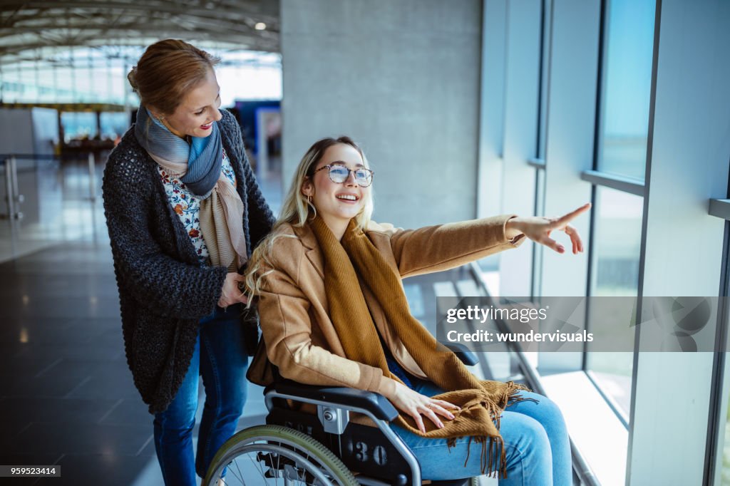 Young disabled woman on wheelchair and mother waiting at airport