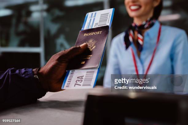hombre sosteniendo pasaportes y embarque pasen en el mostrador de facturación de la aerolínea - ticket counter fotografías e imágenes de stock
