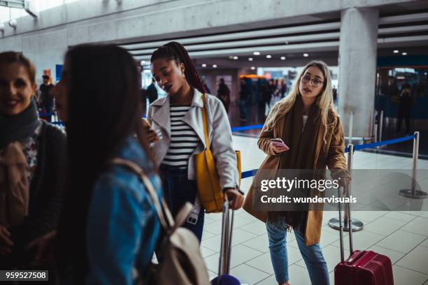 multi-ethnic passengers standing in queue for check-in at airport - lining up imagens e fotografias de stock