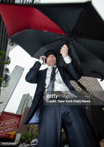 Lawyer Aaron Schlossberg, the man who ranted against the people speaking Spanish in a Midtown restaurant, covers him self with an umbrella to block...