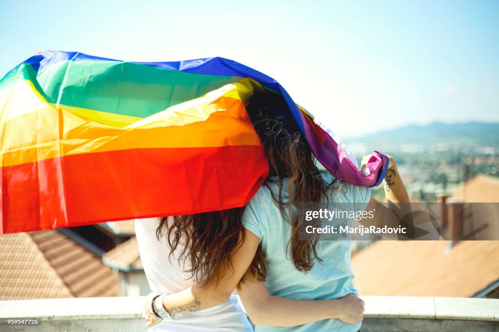 LGBT-lesbisches paar Momente Glück Konzept. Regenbogenfahne halten im freien