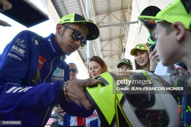 Movistar Yamaha MotoGP's Italian rider Valentino Rossi signs autographs for young fans following a press conference before a motoGP free practice...