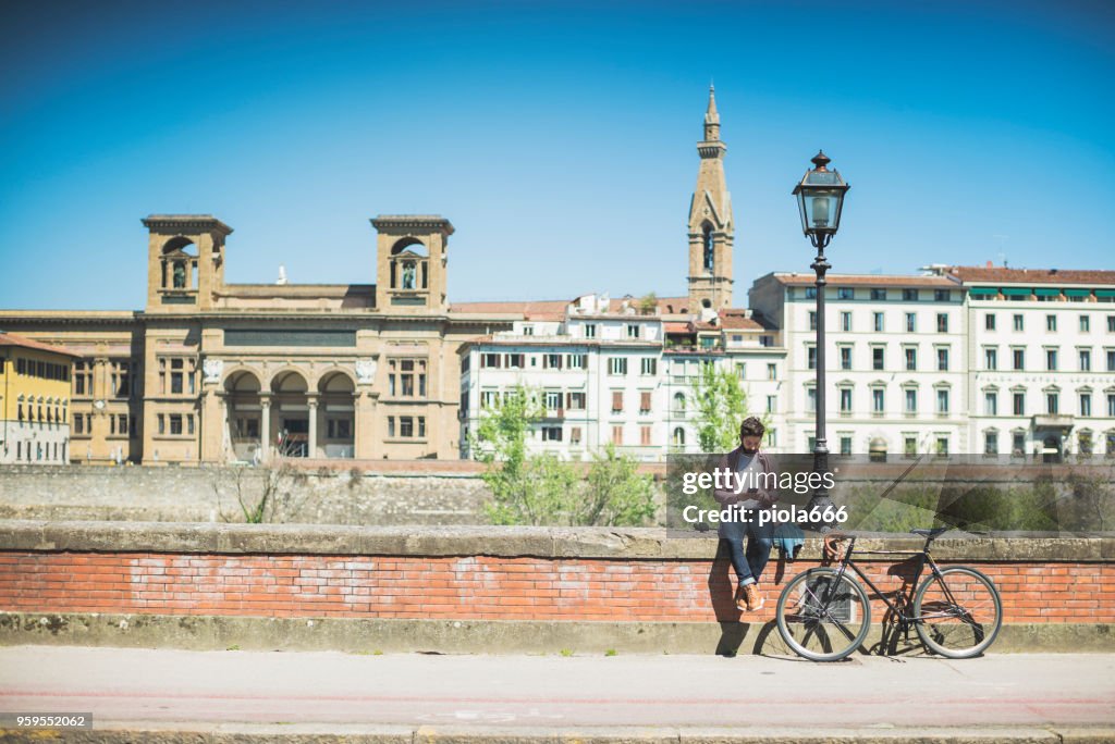 Hipster chico con bicicleta en Florencia, Italia