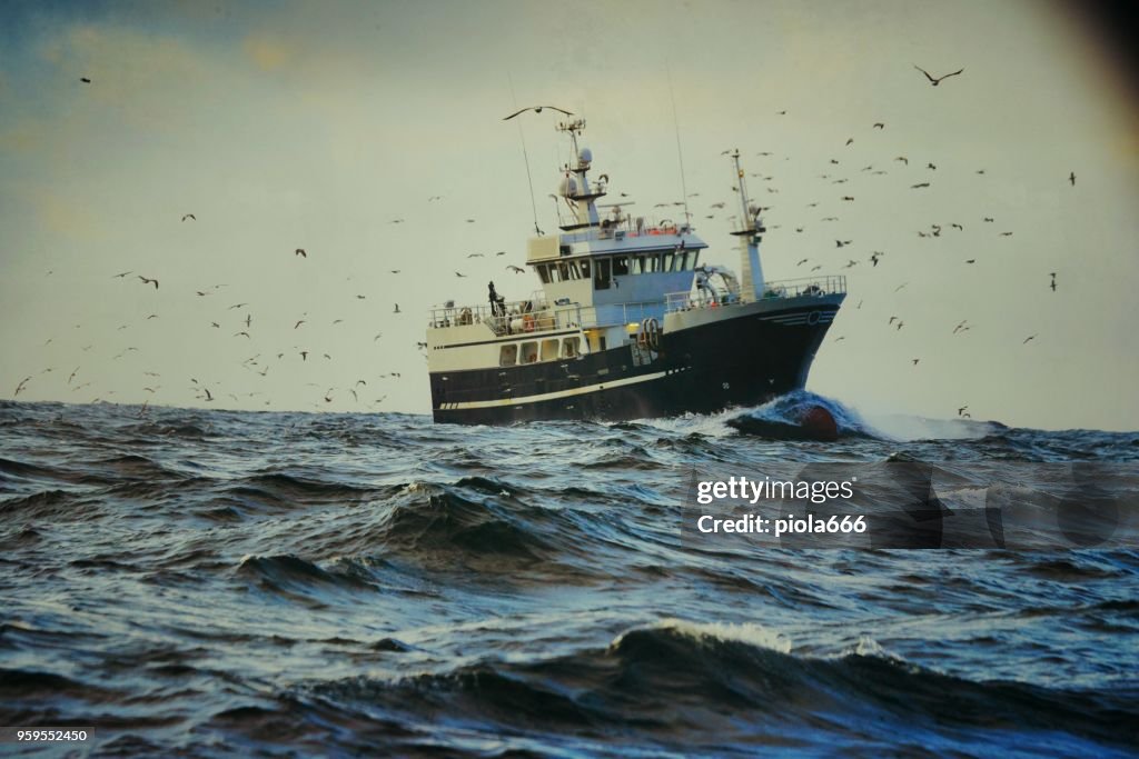 Fishingboat vessel fishing in a rough sea