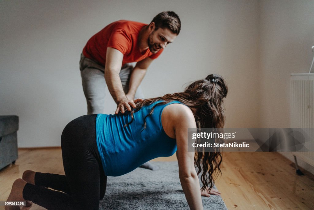 Pregnant woman doing yoga with her husband