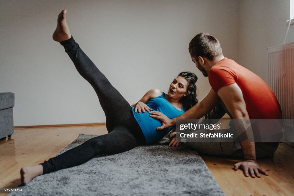 Pregnant woman doing yoga with her husband