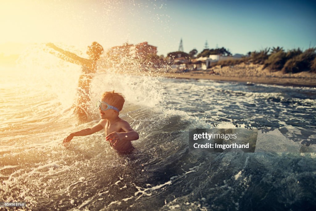 Brother and sister splashing in summer sea