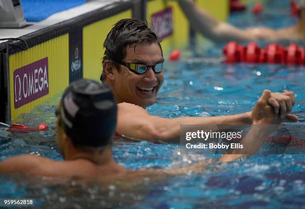 Nathan Adrian, right, shakes the hand of Matt Grevers after winning the men's 100 meter freestyle prliminary race during the TYR Pro Swim Series at...