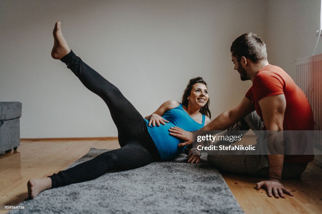 Pregnant woman with husband exercising