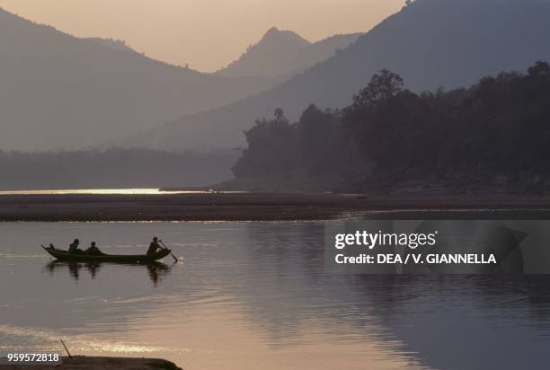 Boat on the Mekong River at sunset, near Luang Prabang, Laos.