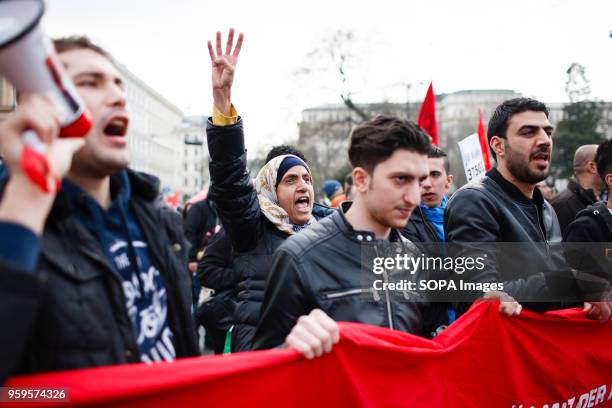 Pro-refugee demonstrators protest outside the Austrian parliament building one month after the government announced the introduction of daily caps to...