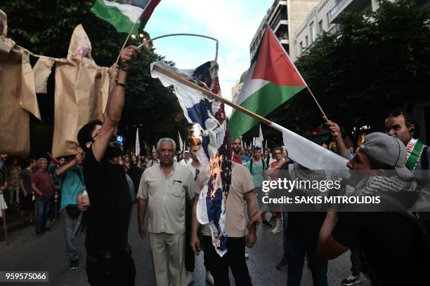 Palestinians who live in Thessaloniki burn an USA and an Israeli flags in front of the US consulate during a demonstration on May 17 to denounce the...