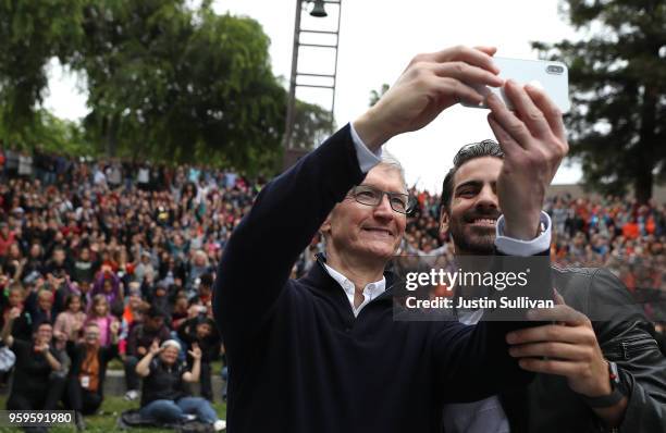 Apple CEO Tim Cook and cctor, model, and activist for the deaf community Nyle DiMarco take a selfie with students at the California School for the...