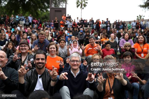 Apple CEO Tim Cook and actor, model, and activist for the deaf community Nyle DiMarco gesture while taking a picture with students at the California...