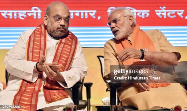 Prime Minister Narendra Modi speaks with BJP National President Amit Shah during the concluding session of the National Executive Committee meeting...