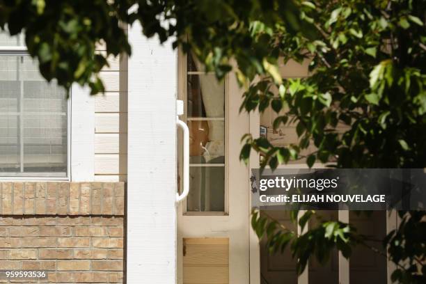 An unidentified person is seen peeking inside the home where 10 children were allegedly tortured and abused on May 17 in Fairfield, California. - A...