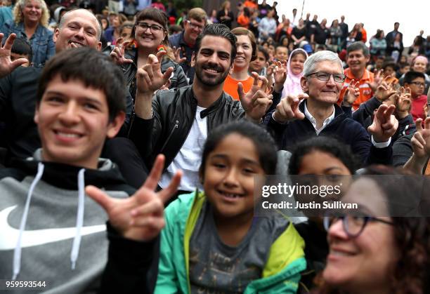 Apple CEO Tim Cook and actor, model, and activist for the deaf community Nyle DiMarco gesture while taking a picture with students at the California...