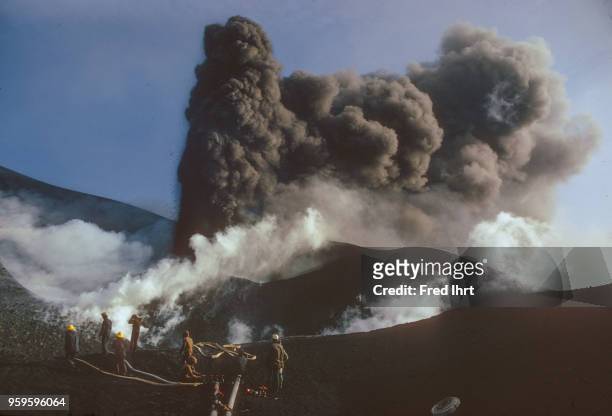 Volcano eruption on Heimaey Island in Iceland on 23 January 1973. Firefighter working on controlling the lava flow by cooling it down with water so...