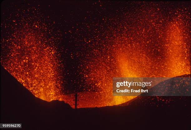 Volcano eruption on Heimaey Island in Iceland on 23 January 1973. Lava and ashes are getting spit up in the air at night.