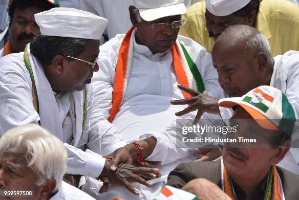 Outgoing Chief Minister of Karnataka Siddaramaiah speaks to Janata Dal leader Deve Gowda as the leader of opposition Lok Sabha Mallikarjun Kharge...