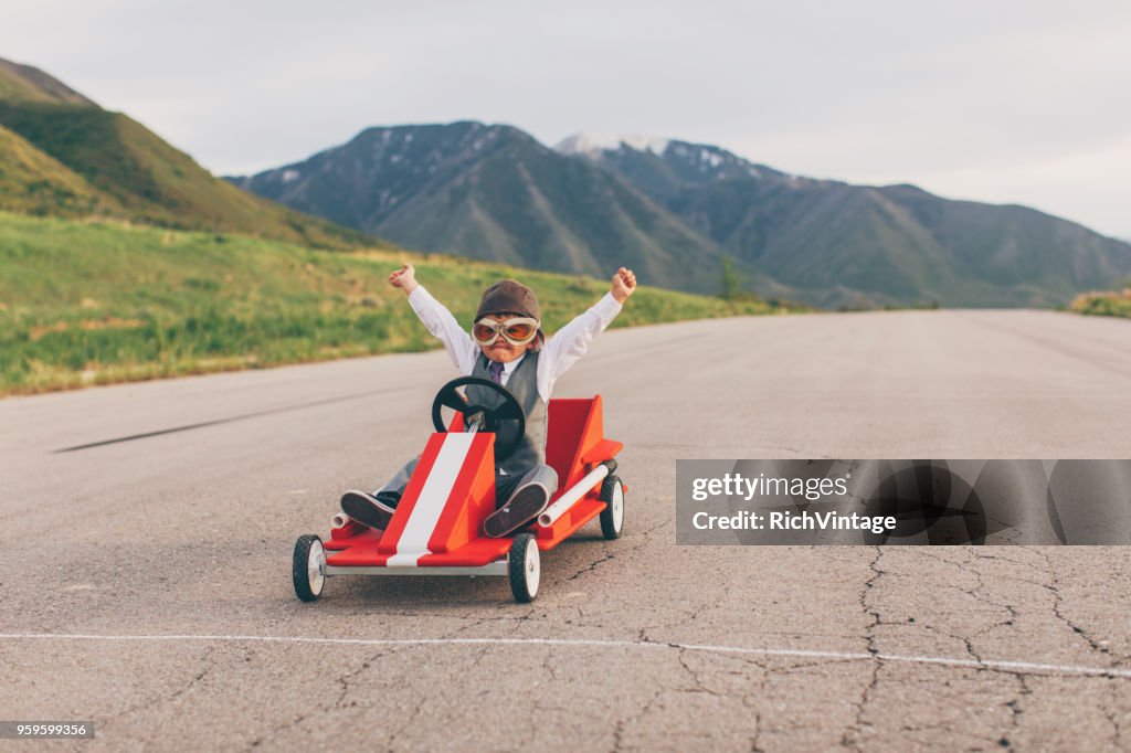 Junge Junge Geschäftsabschlüsse gehen Kartrennen