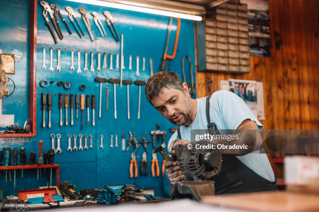 Manual worker repairing electric motor in a workshop