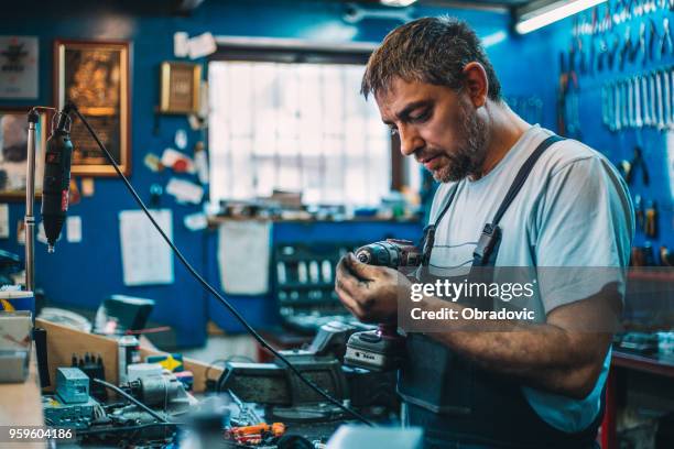 werknemer werkt aan boor in een workshop - drill bit stockfoto's en -beelden