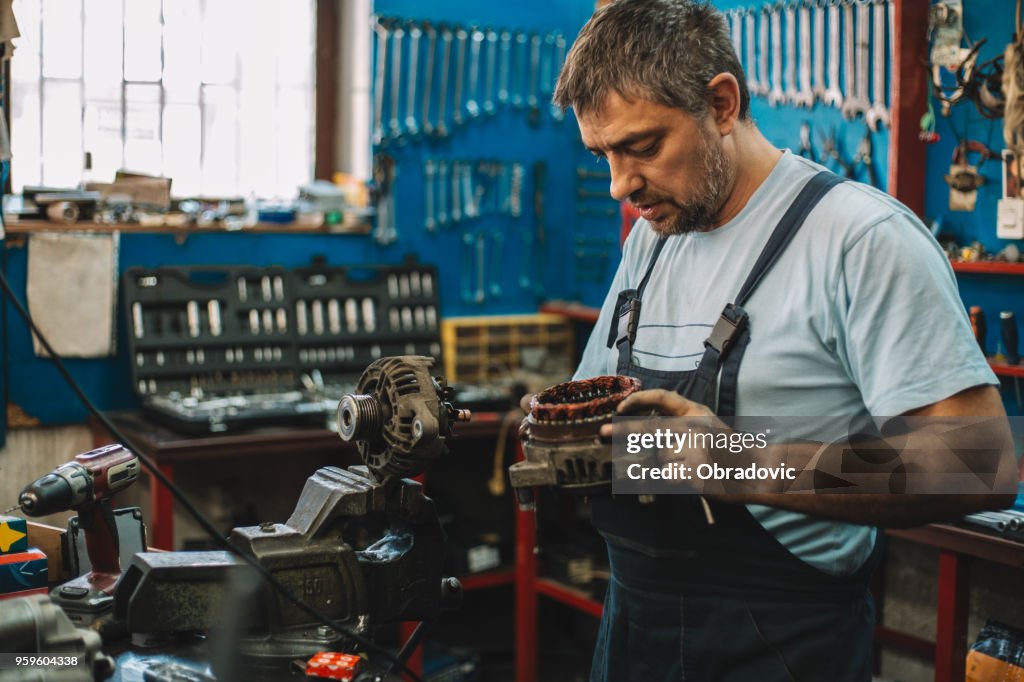 Manual worker repairing electric motor in a workshop