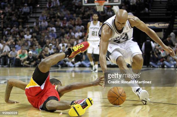 Forward Trevor Ariza of the Houston Rockets falls while reaching for the ball against Richard Jefferson of the San Antonio Spurs at AT&T Center on...