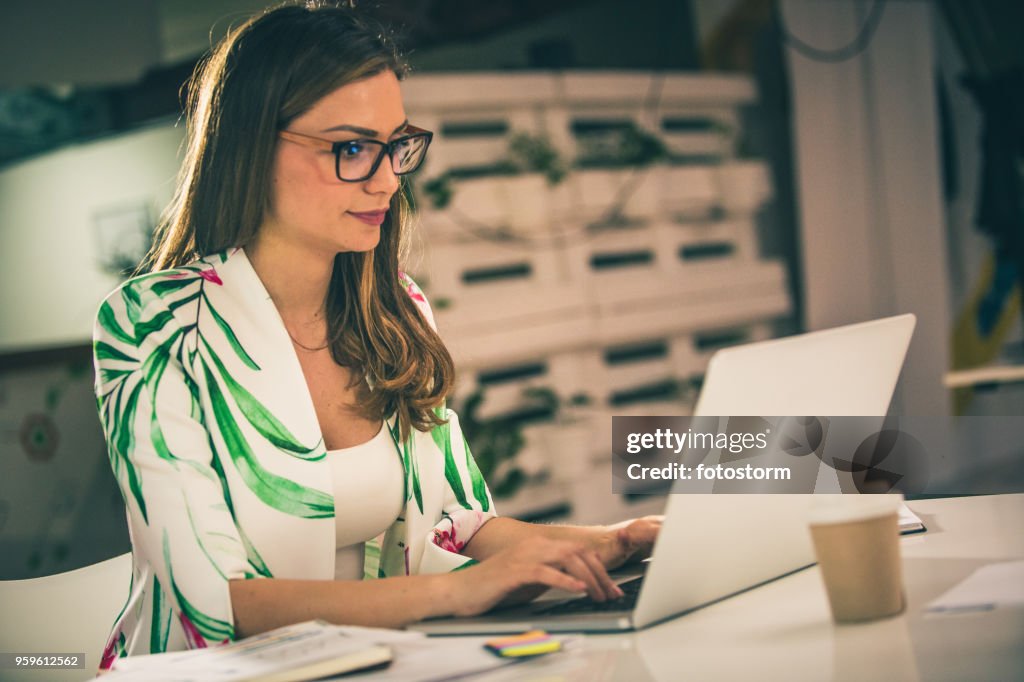 Jonge vrouw die op laptop werkt