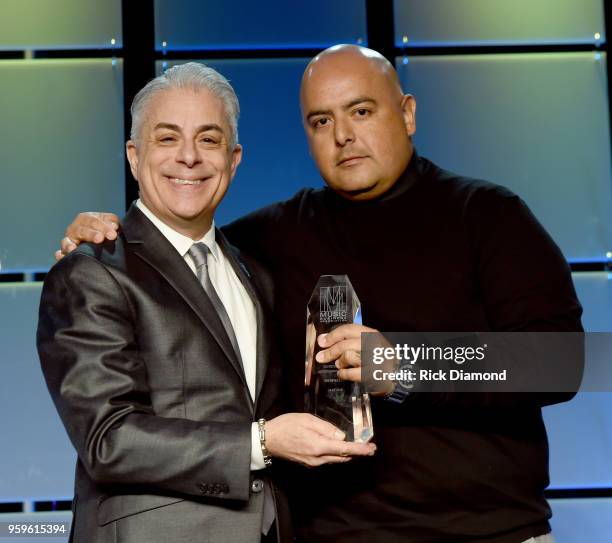 President of Music Business Association, James Donio presents an award to Armando Rodriguez, Senior VP of Universal Music Latin Entertainment onstage...