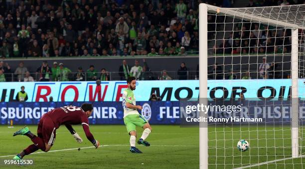 Yunus Malli of Wolfsburg scores his team's third goal against goalkeeper Kenneth Kronholm of Holstein Kiel during the Bundesliga Playoff Leg 1 match...