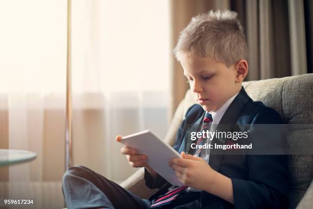 portrait of a cute little business man checking tablet - adult imitation stock pictures, royalty-free photos & images