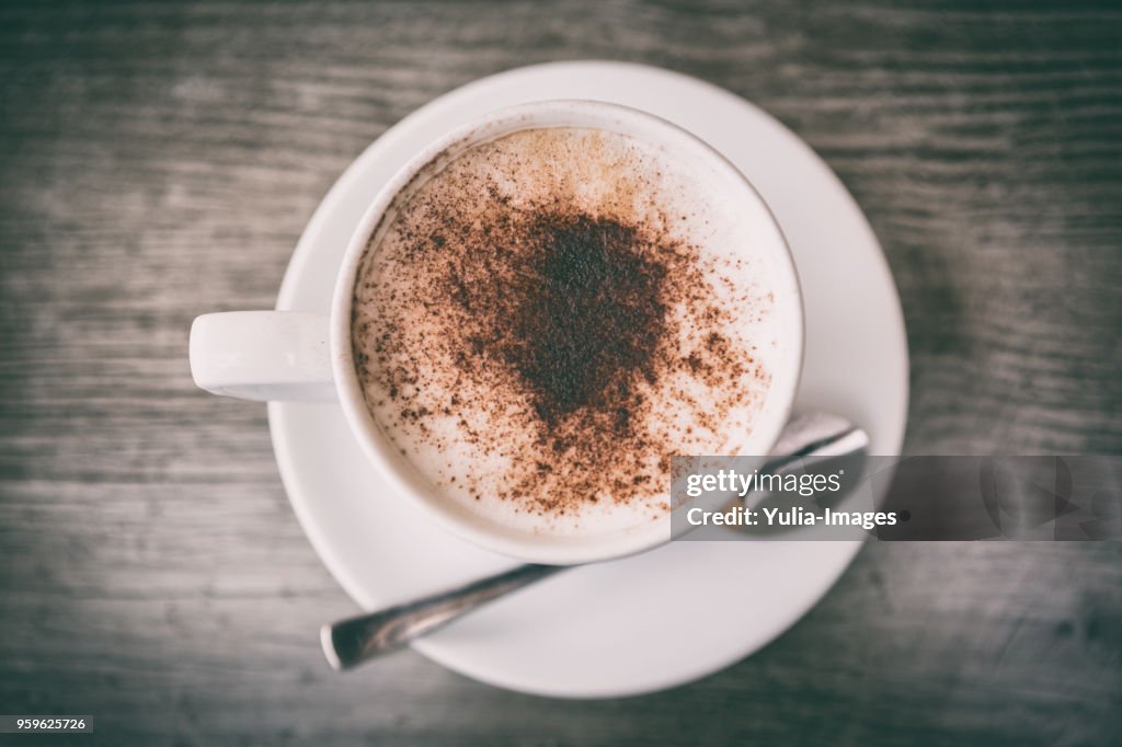Fresh brewed cappuccino coffee with milk in a white cup
