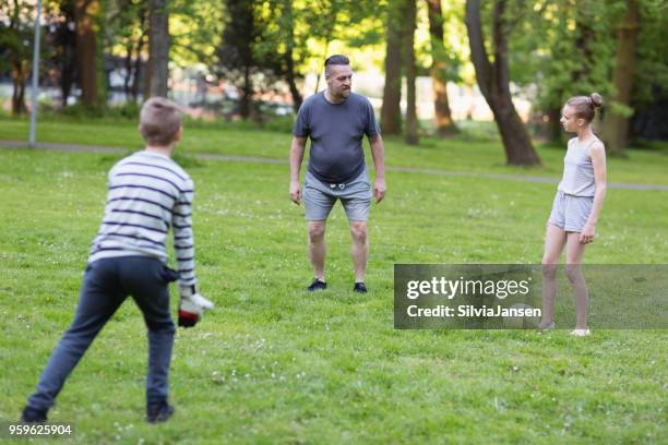 vader te voetballen met jongen en meisje in park - fussball kinder stockfoto's en -beelden