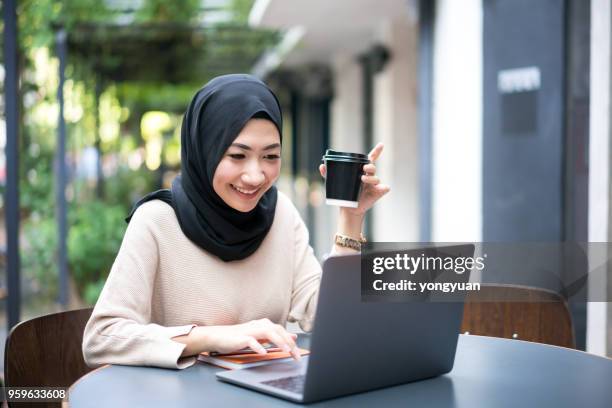 smiling malaysian girl using her laptop - yongyuan stock pictures, royalty-free photos & images