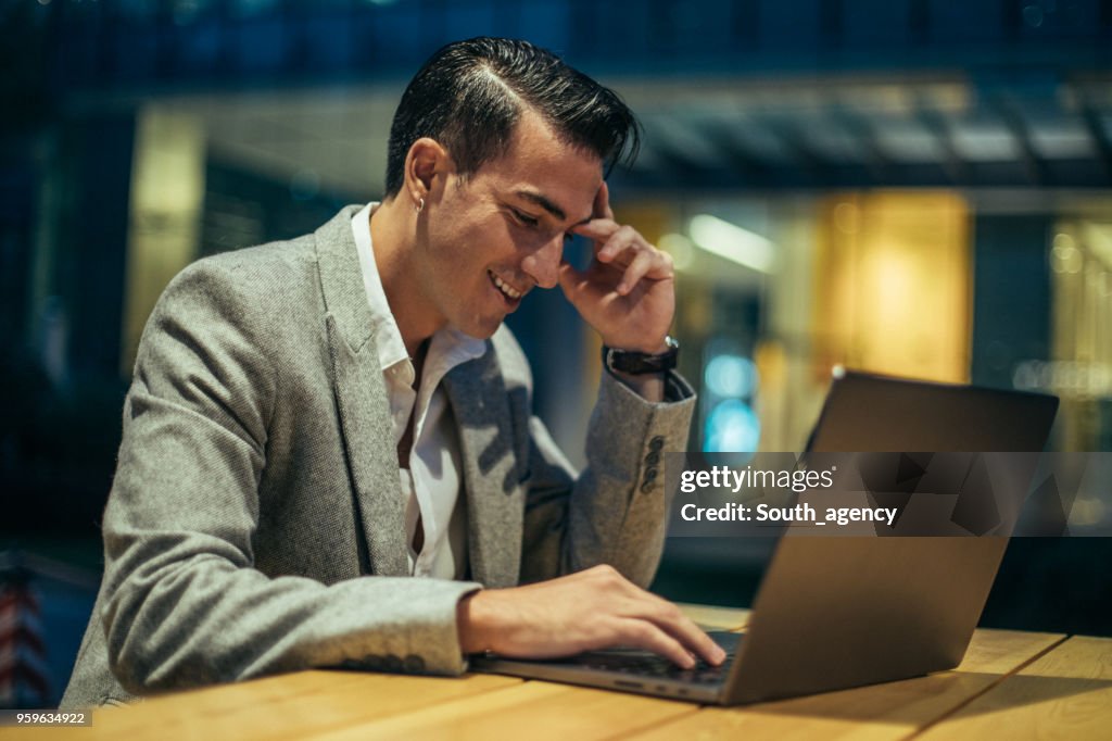 Hombre trabajando en ordenador portátil en la tienda de café