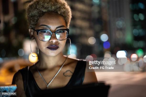 young woman using tablet at night - bokeh lights tablet stock pictures, royalty-free photos & images