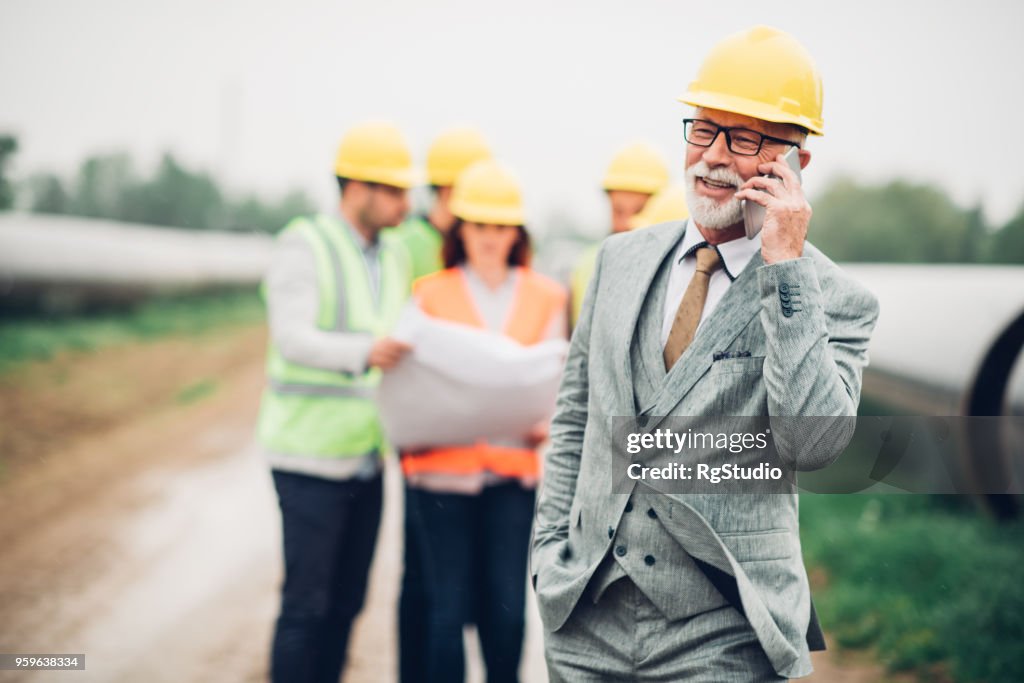 Happy old business man using phone