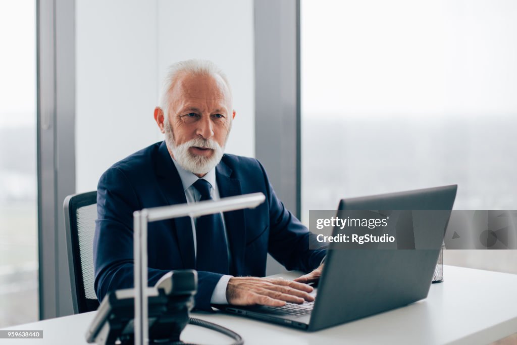 Elderly business man using laptop