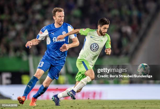 Yunus Malli of VfL Wolfsburg in action with Dominic Peitz of Holstein Kiel during the Bundesliga Playoff Leg 1 match between VfL Wolfsburg and...
