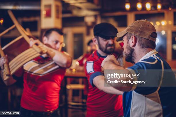 hommes faisant valoir au bar des sports - se battre photos et images de collection